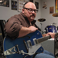 My dad showing off his favorite guitar while in his office
