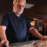 Serious man playing pinball