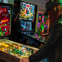The side of a woman playing pinball