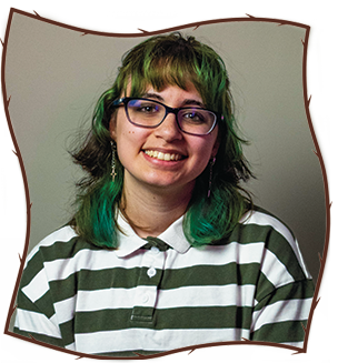 Image of me wearing green and brown shoulder length hair, blue glasses, and a green/white striped shirt